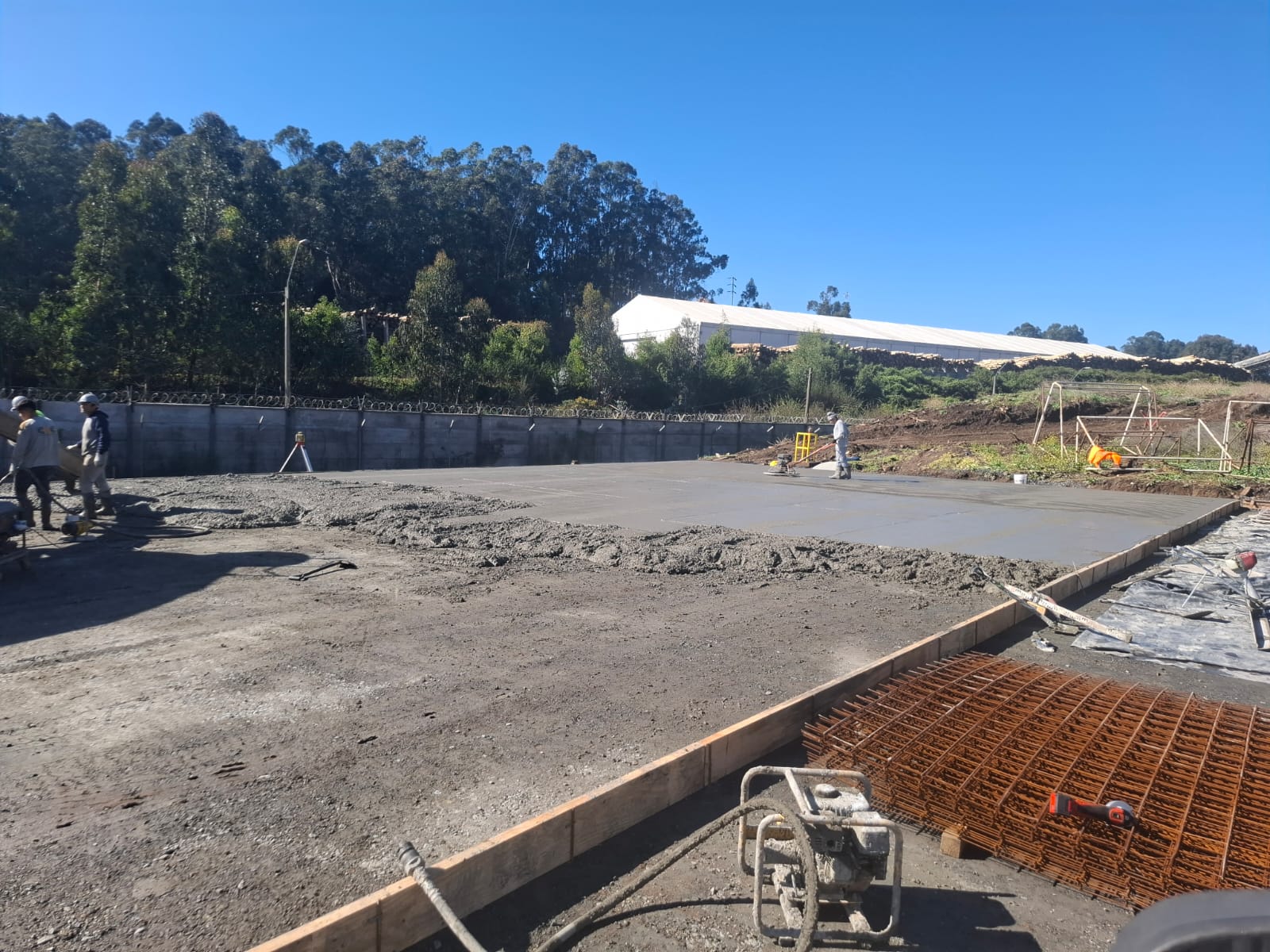 Vertido y nivelación de losa de hormigón en planta industrial